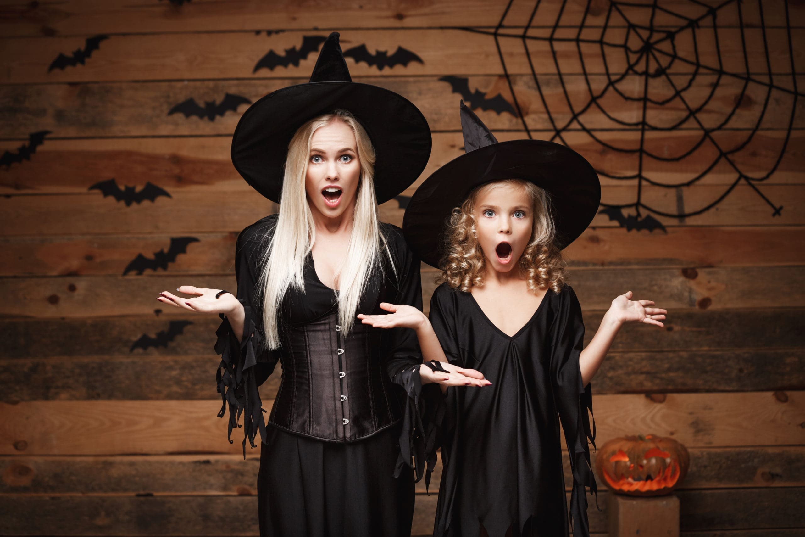 Concept d'Halloween - mère joyeuse et sa fille en costumes de sorcière choquants avec quelque chose.