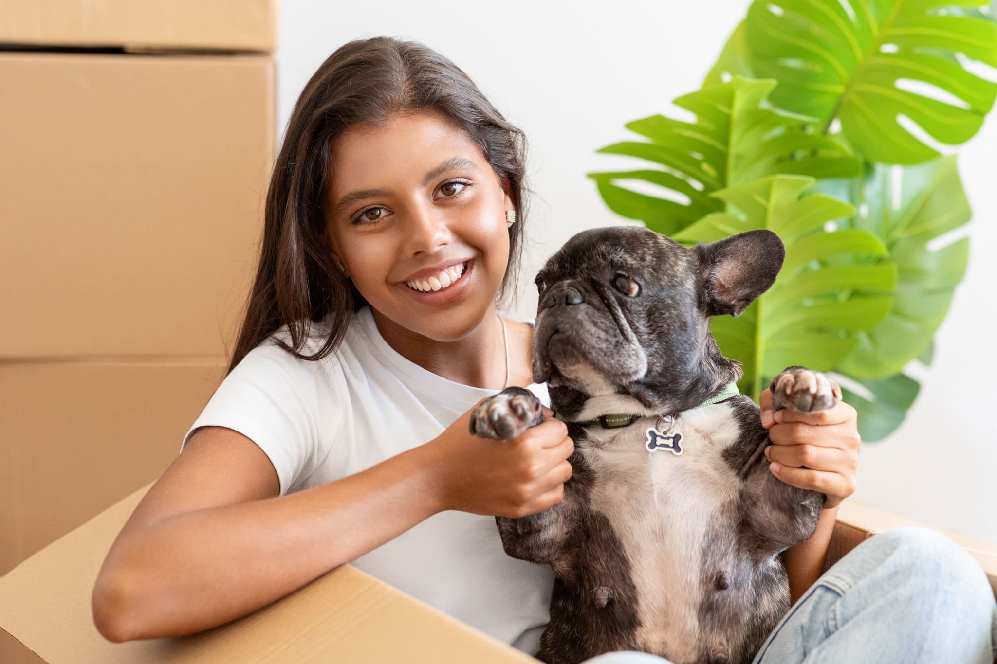 Cheerful woman sitting in a box with her dog